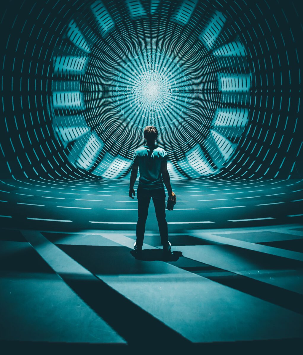 A person standing in a glowing tunnel of light, looking forward